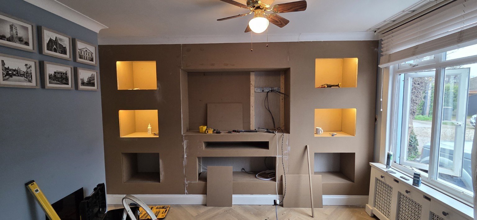 Media-wall cabinetry and illuminated display cubbies before painting